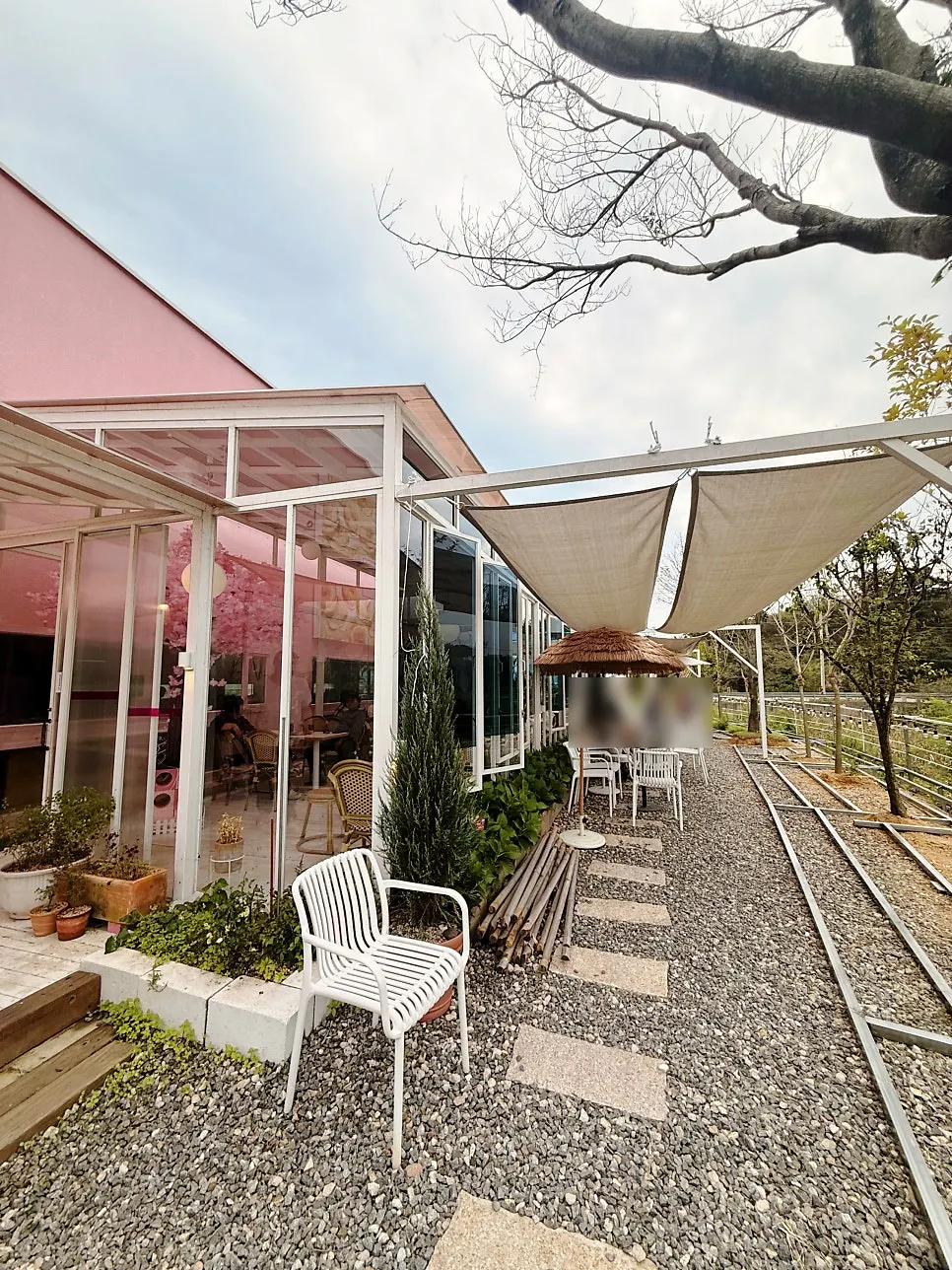 Vertical photo with the Pink Wall Cafe exterior as backdrop