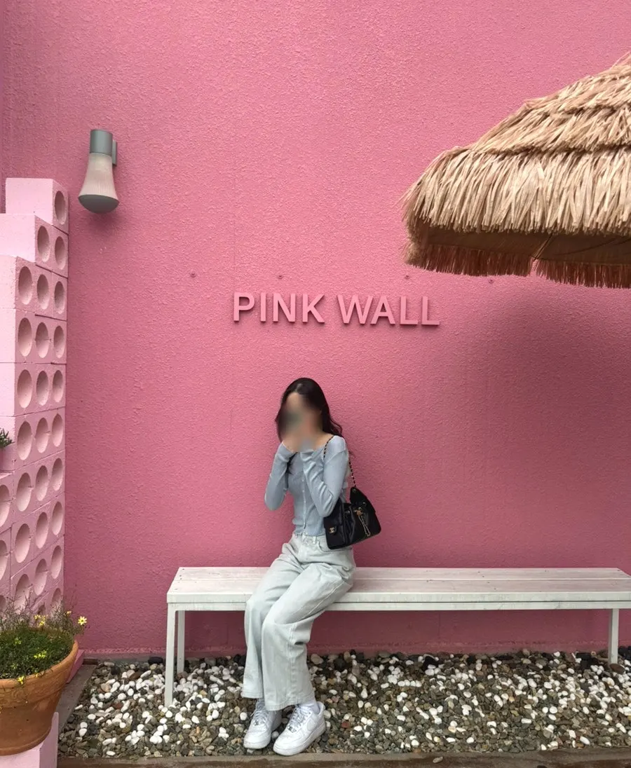 Exterior of Pink Wall Cafe surrounded by greenery