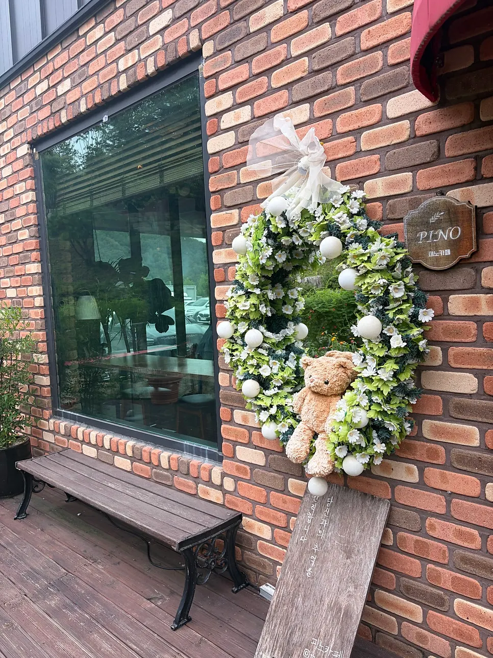 Pino Cafe's summer photo zone decorated with a bear and a yellow-roofed house