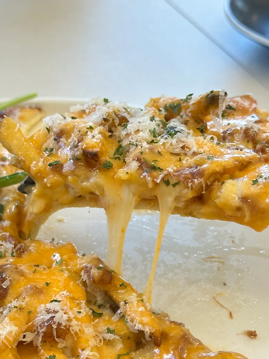 A slice of the potato pizza piled with french fries
