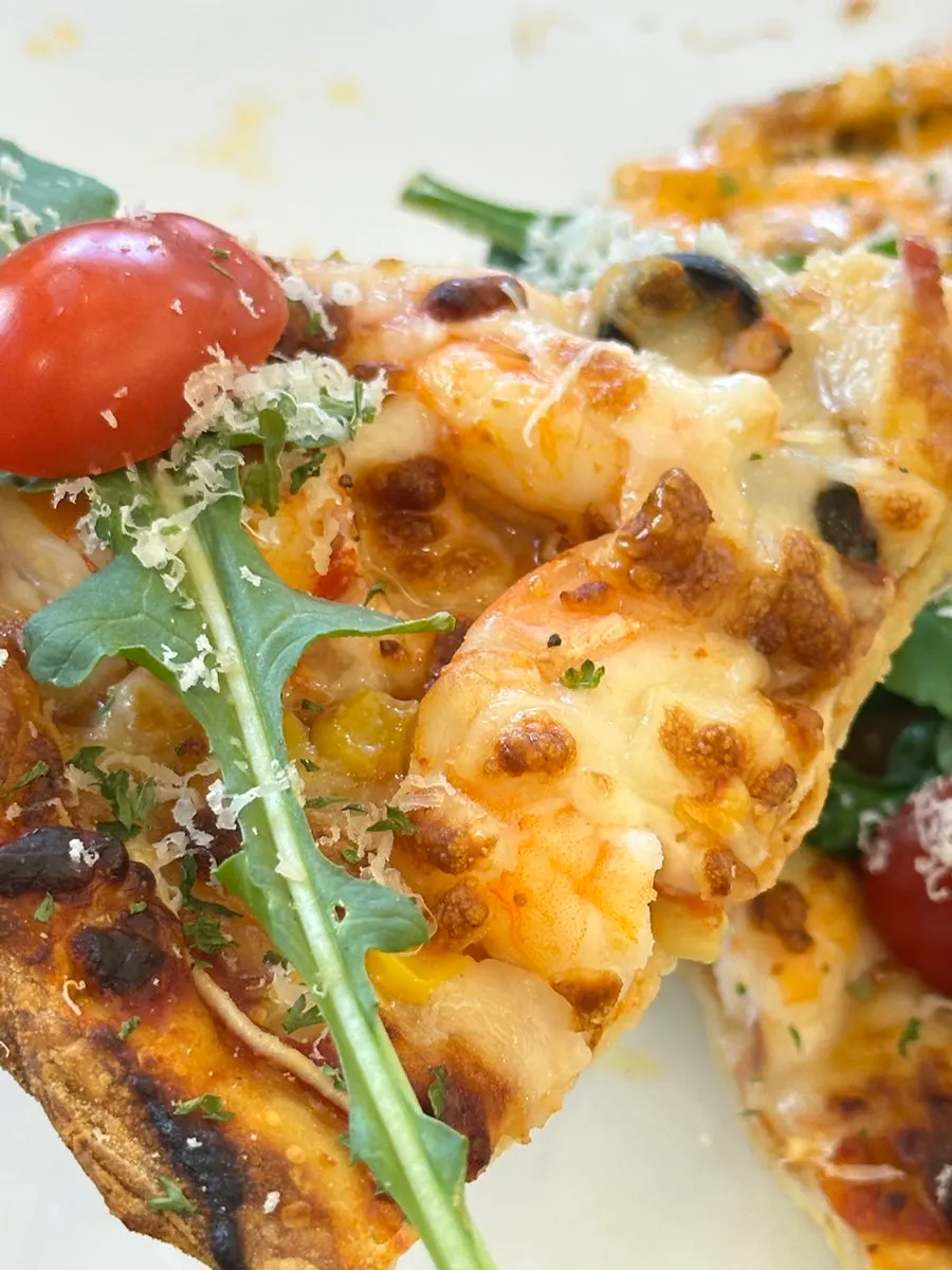 A slice of half-and-half pizza with stretchy cheese