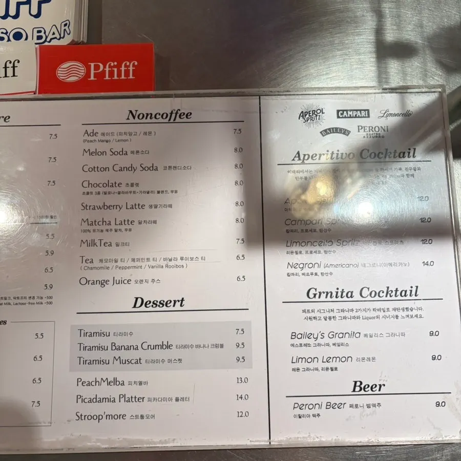 Menu board listing espresso, desserts, and cocktails