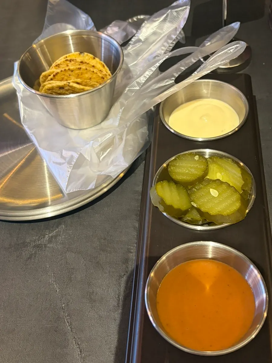Complimentary nachos, pickles, and sauce