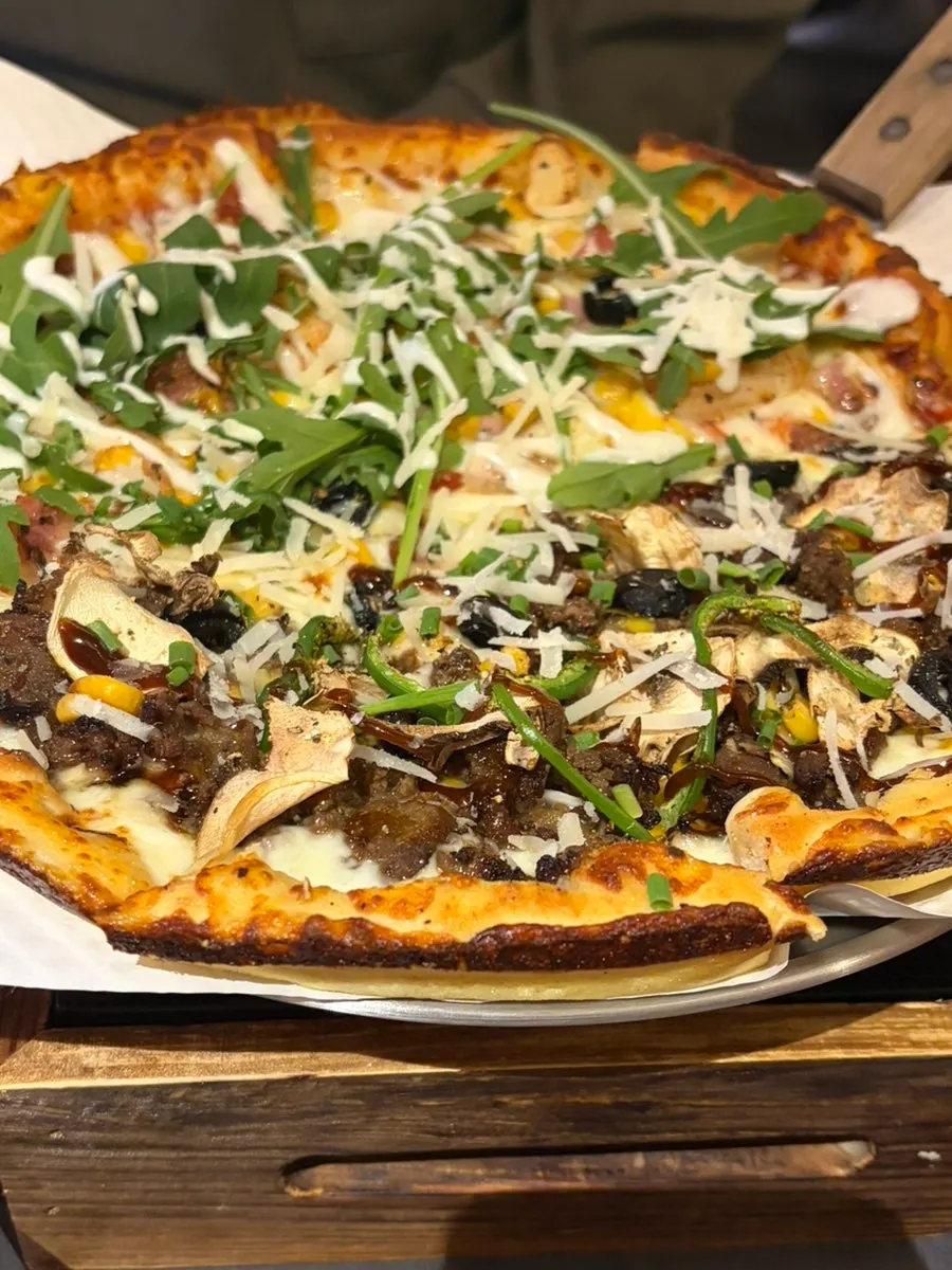 Half-and-half pizza with rucola garlic shrimp and Philly cheese barbecue steak
