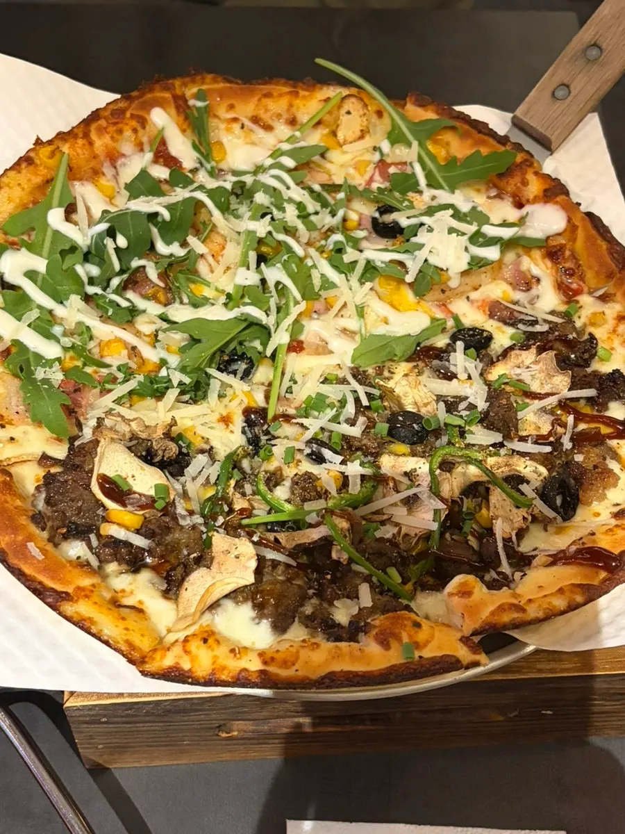 A whole half-and-half pizza piled high with toppings
