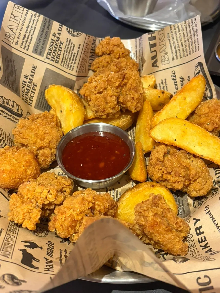 A plate of crispy boneless chicken and potato wedges