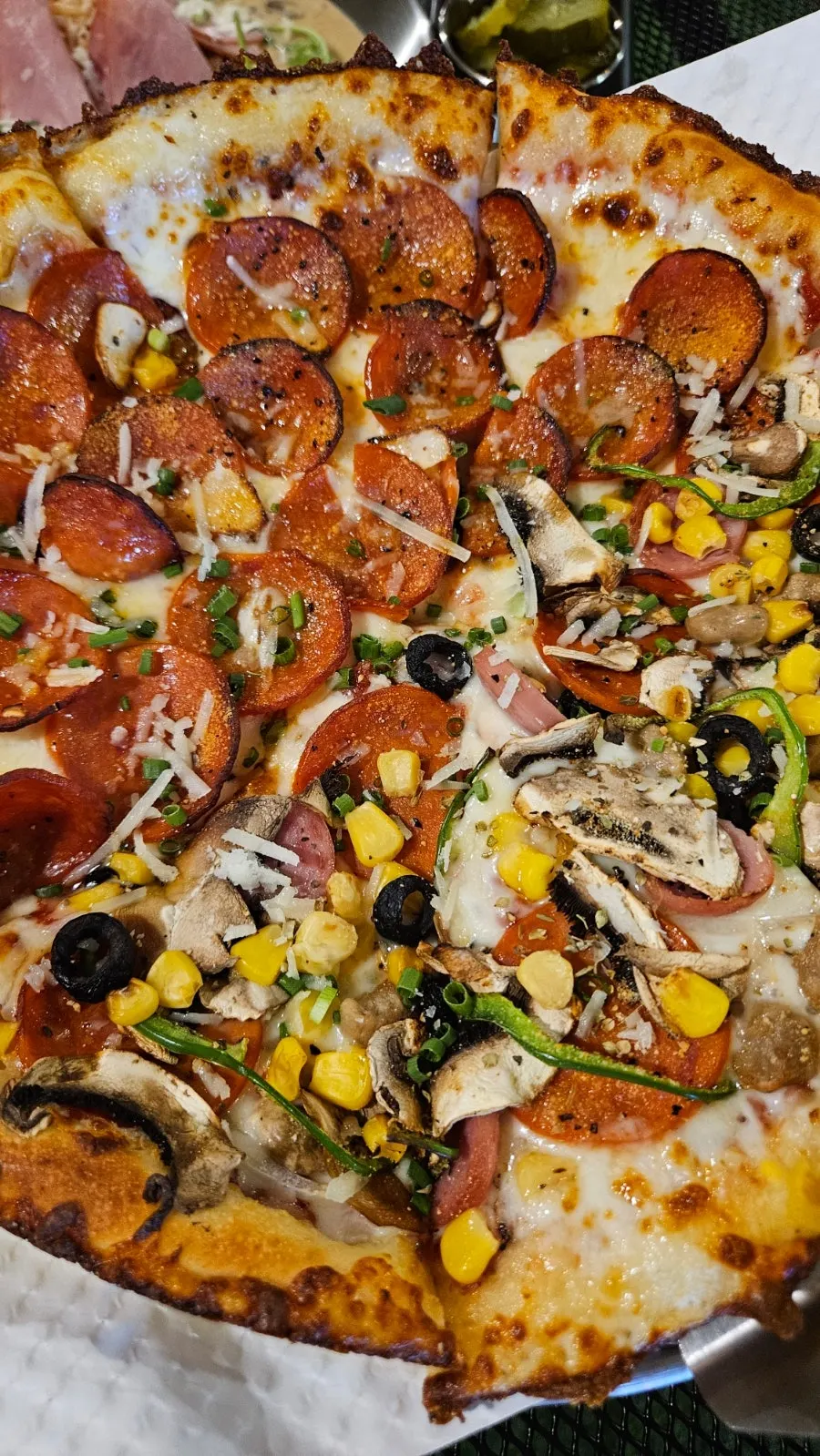 Holding up a slice of the half-and-half pizza