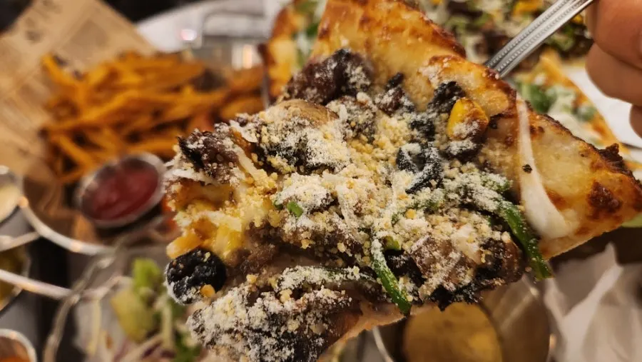 Pizza slice sprinkled with cheese powder