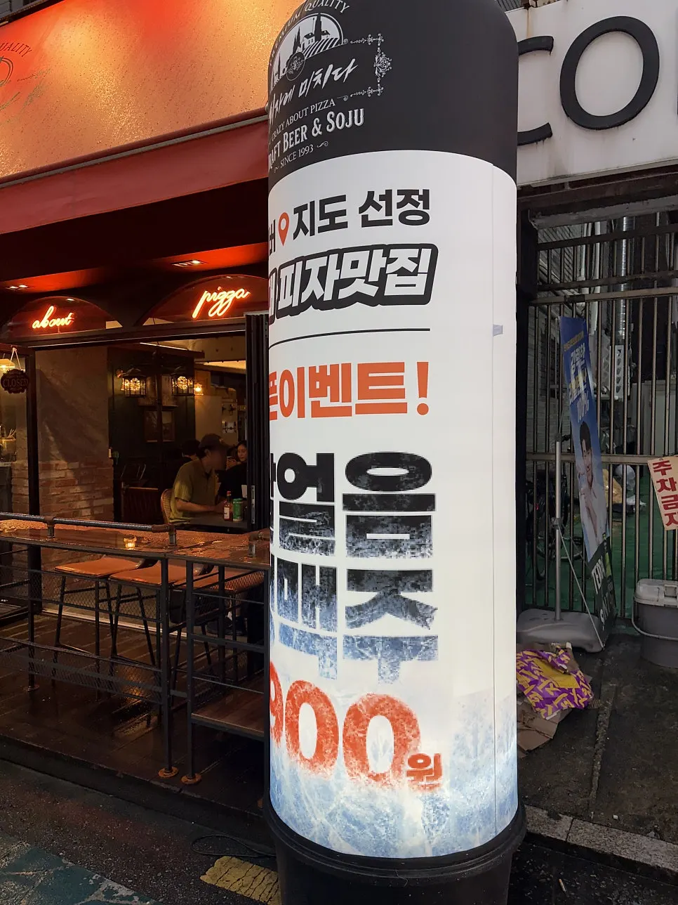 입구에 붙은 피자 메뉴와 맥주 할인 안내