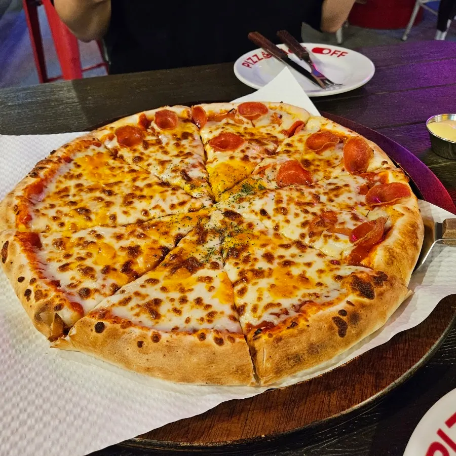 A cold draft beer with a slice of pizza