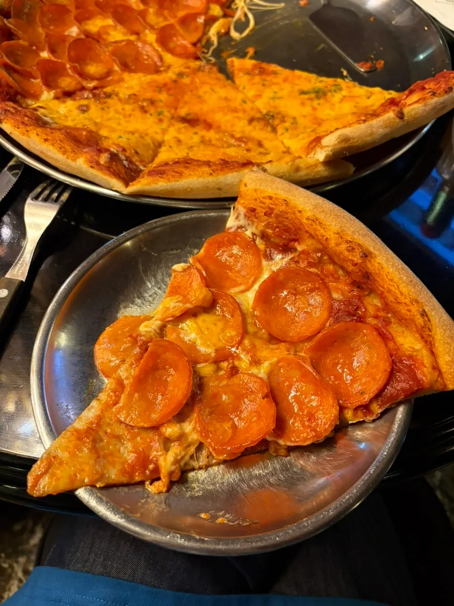 A slice of pepperoni pizza lifted up