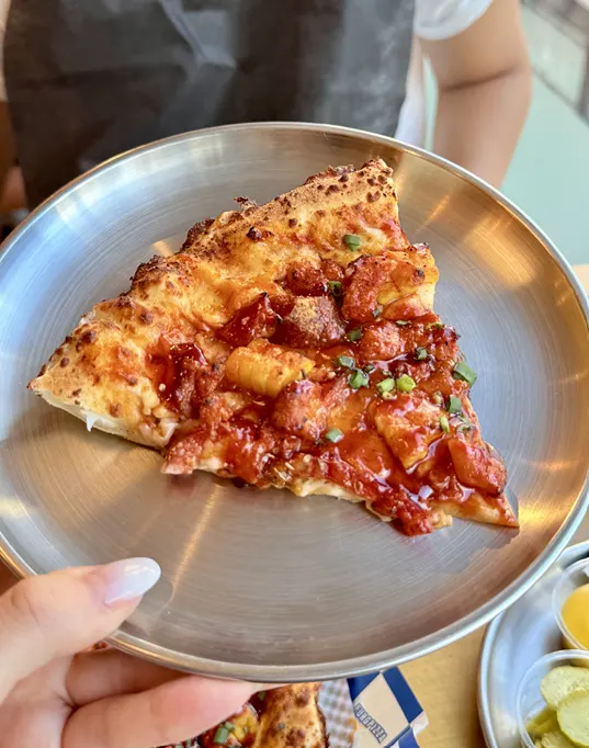 A slice of quattro cheese fire chicken pizza