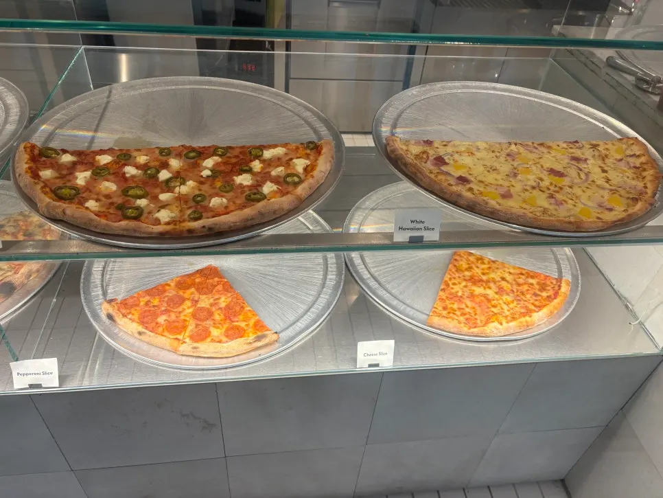 Various slice pizzas displayed in the showcase