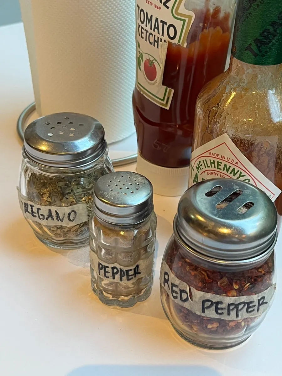 Pepper, hot sauce and other condiments on the table