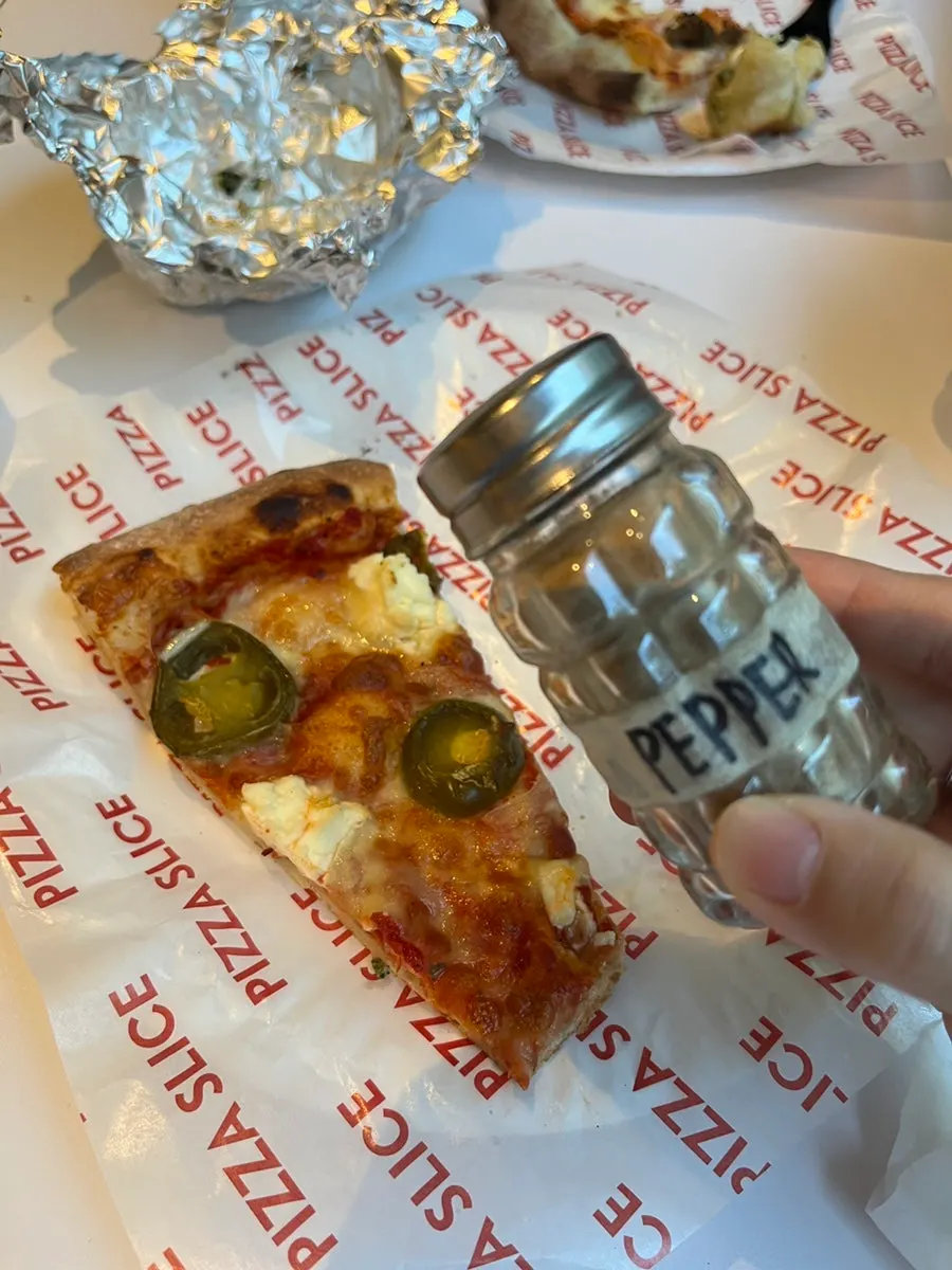 Jalapeño pizza sprinkled with red pepper flakes