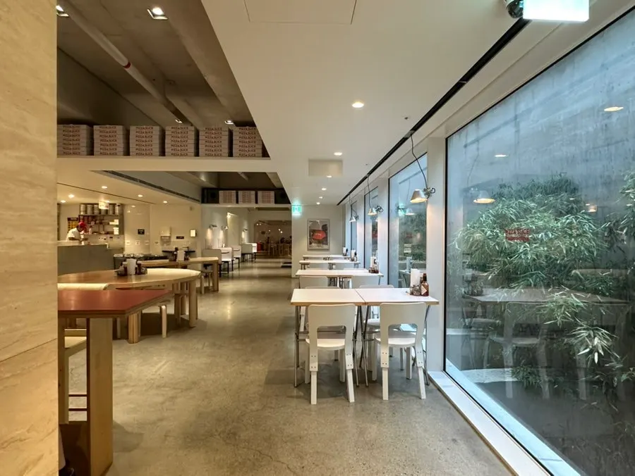 Waiting area with round stools along the white wall