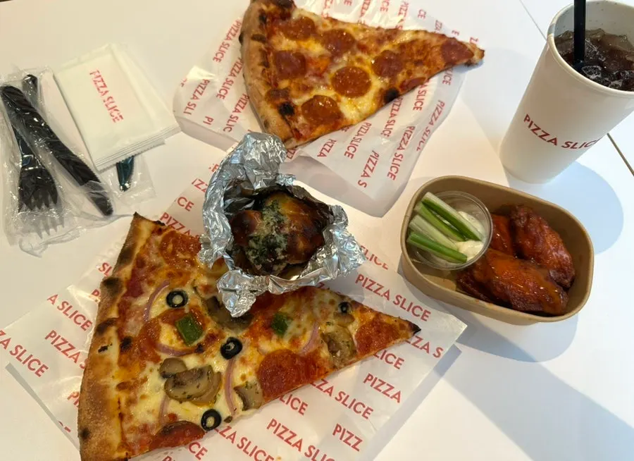 Pizza slices and side dishes set on the table