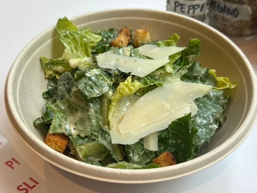 Caesar salad topped with sliced cheese