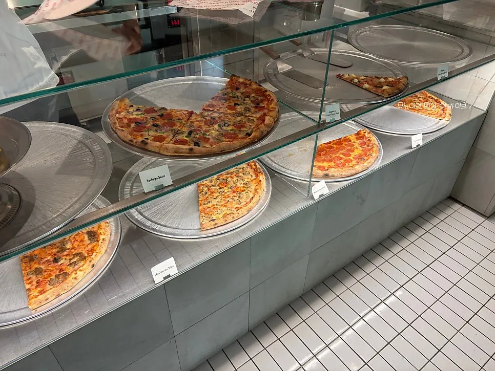 Slice pizzas lined up at the order counter