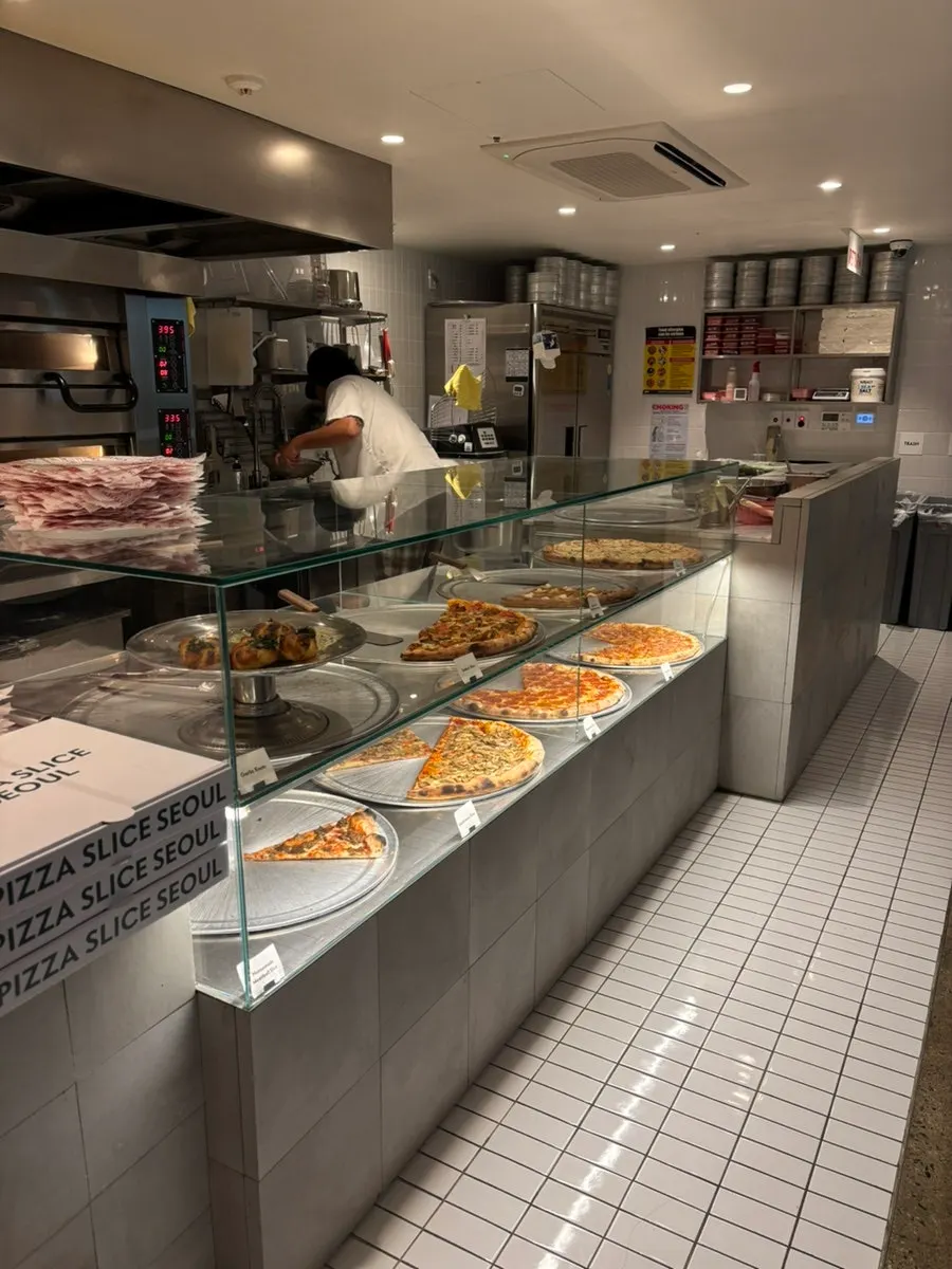 Large slice pizzas displayed in the showcase
