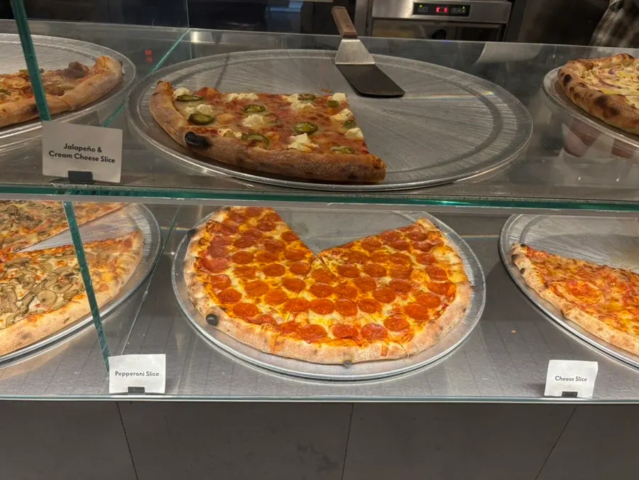 Menu board showing the slice pizza varieties