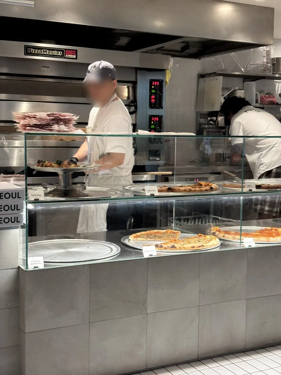 A slice pizza being reheated in the oven