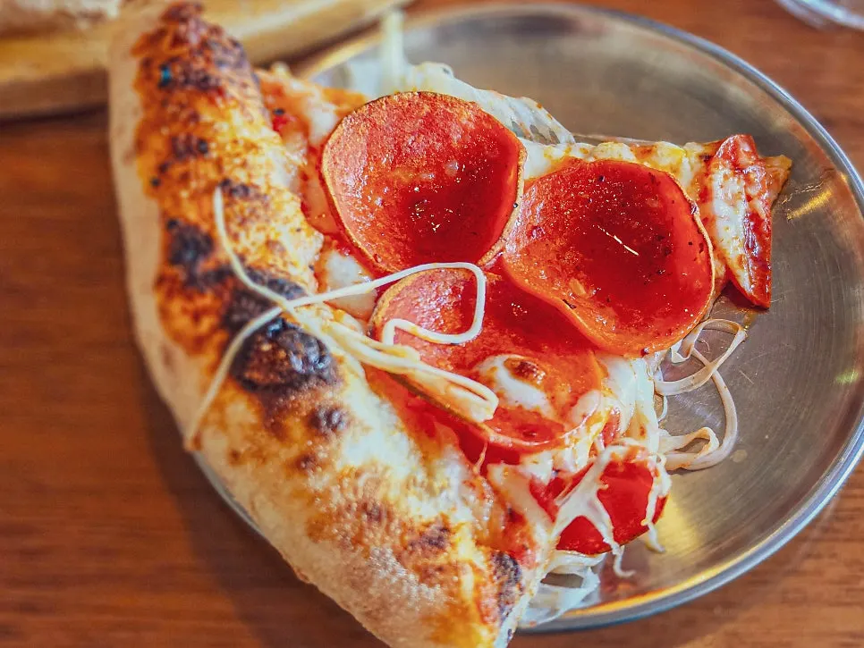 Pizza slice showing the chewy dough