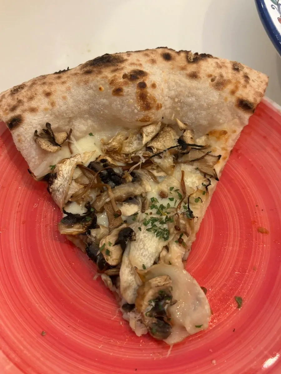 A slice of Funghi pizza loaded with mushroom topping
