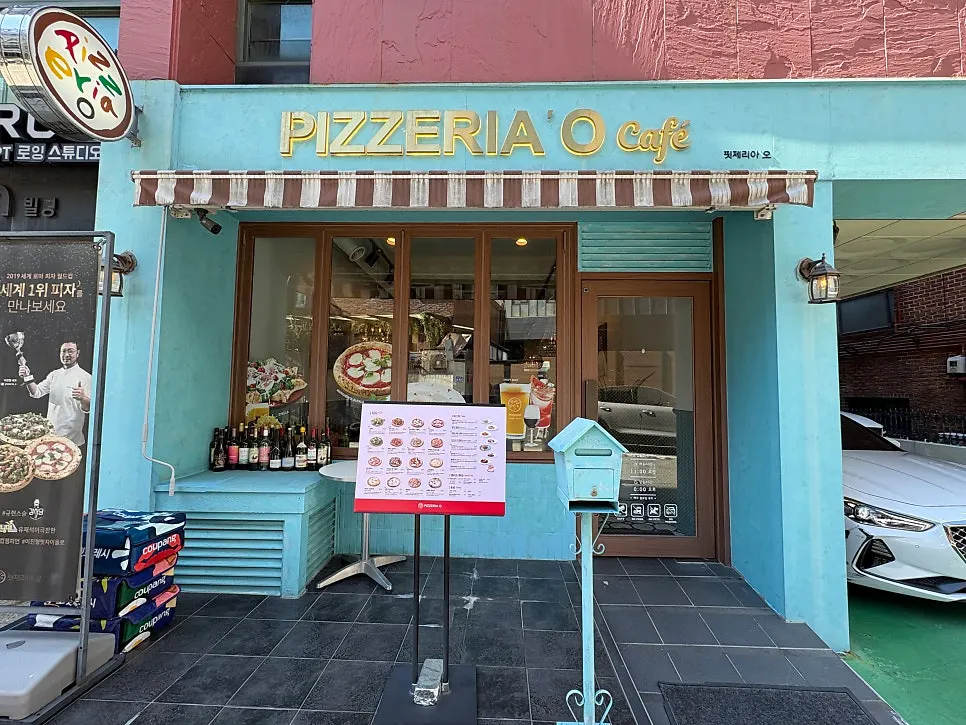 Mint-colored exterior with gold sign at Pizzeria O Hapjeong Station