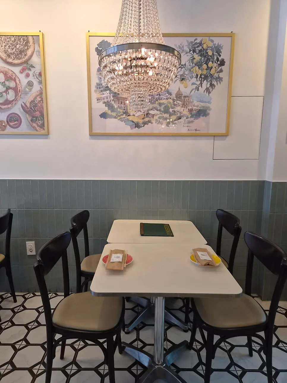 Corner of the restaurant with a chandelier and framed photos