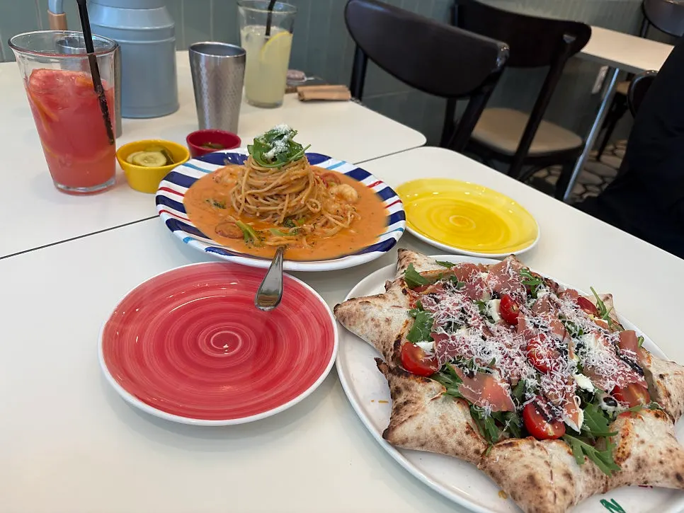 Table set with pizza, pasta and ade together