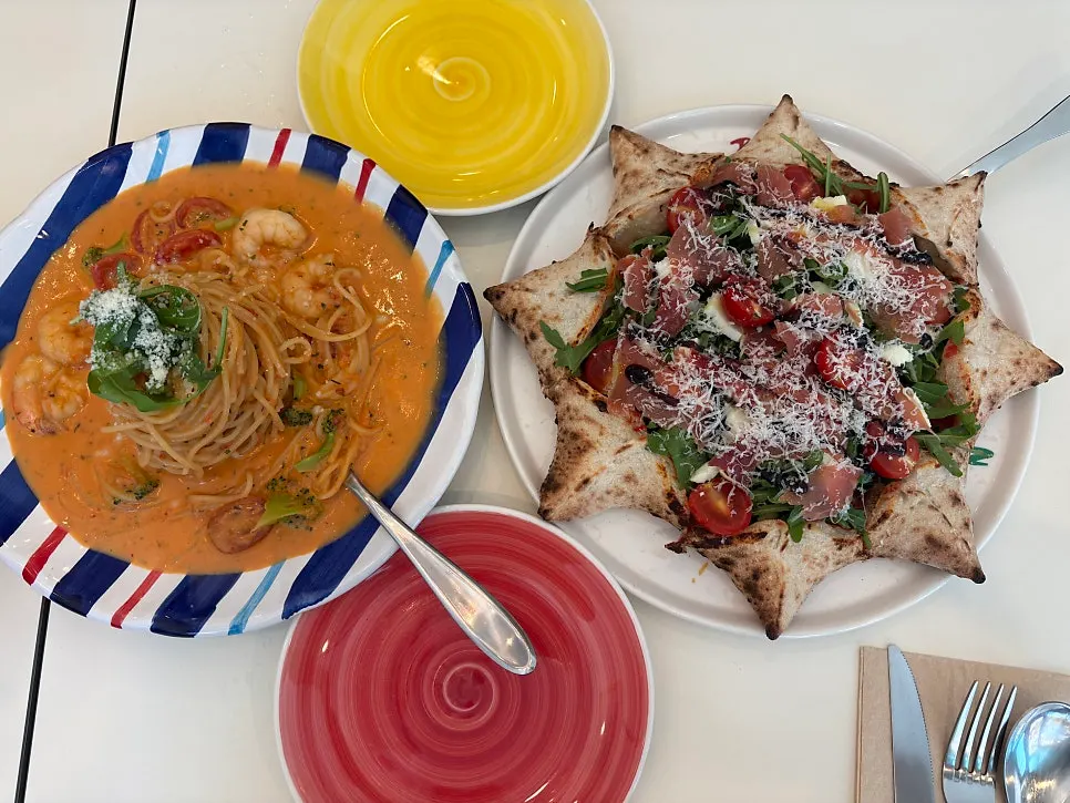 Wood-fired pizza and rosé pasta shared between two people