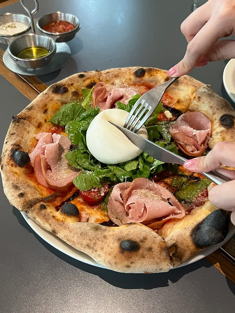 Pizza piled high with arugula and jambon