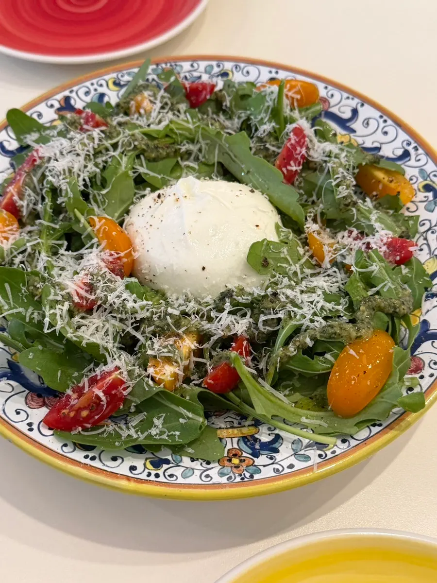 Burrata salad topped with rocket and cherry tomatoes