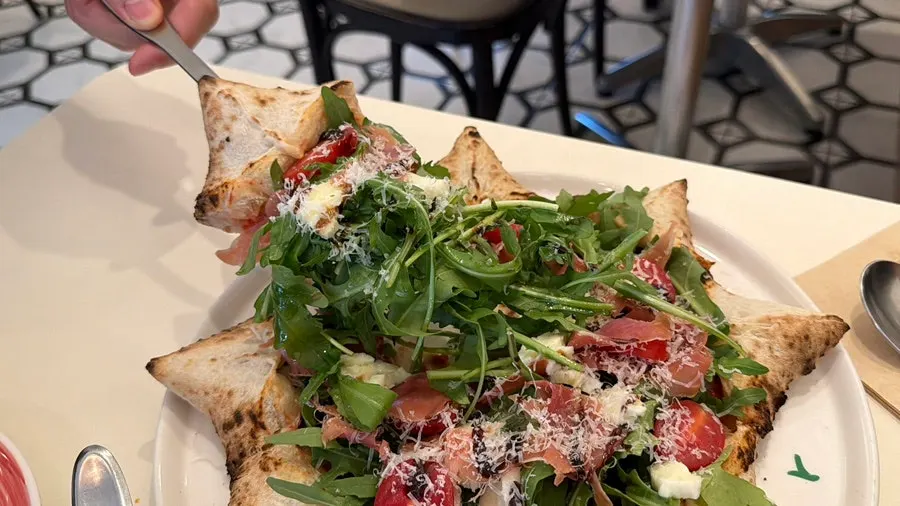 Stella pizza topped with prosciutto and rocket