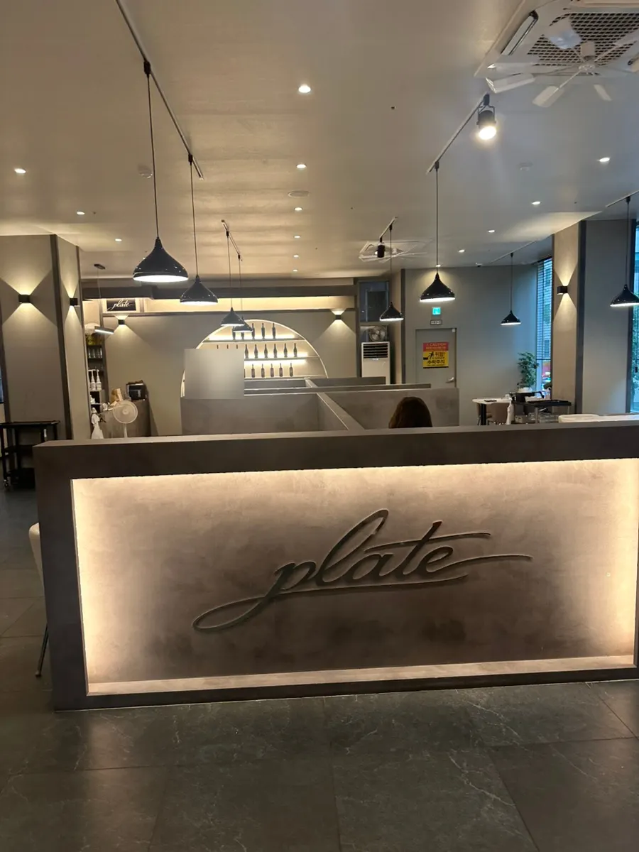 Interior de Plate Dunsan Branch con mesas bien espaciadas