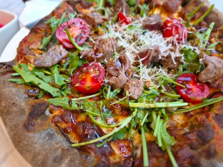 Full view of the fire-grilled pizza topped with chapsteak