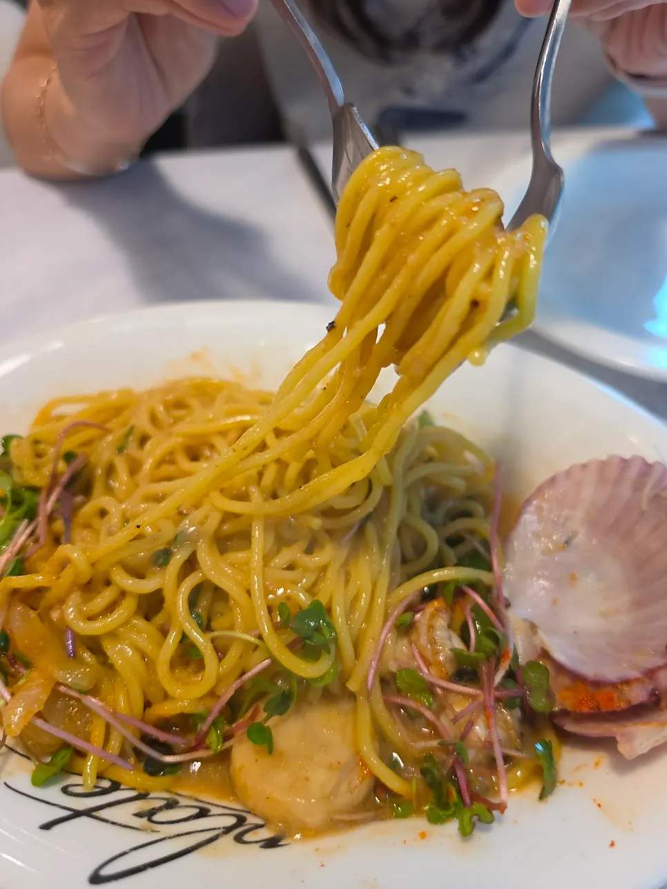 Pasta and scallop twirled on a fork