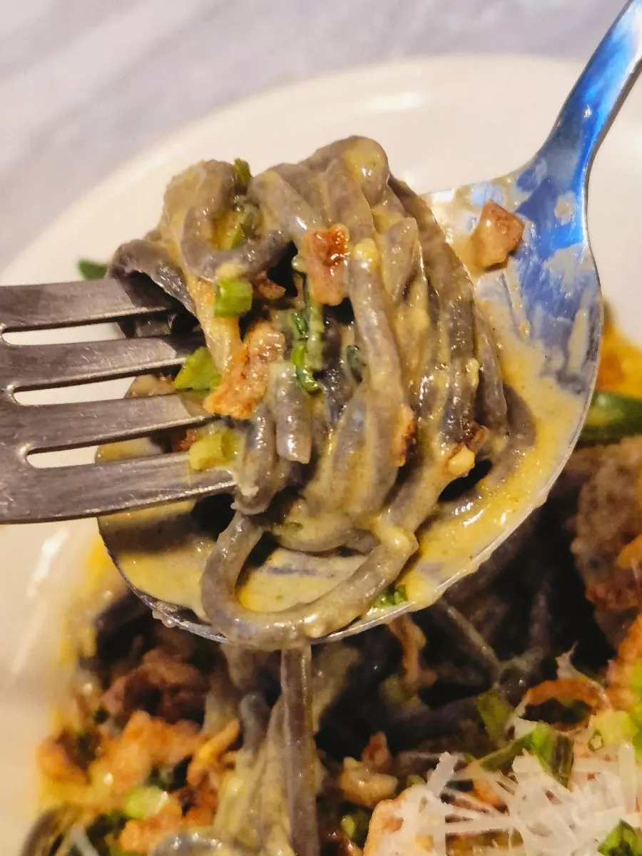 Mi spageti dakwat sotong segar digulung di garfu