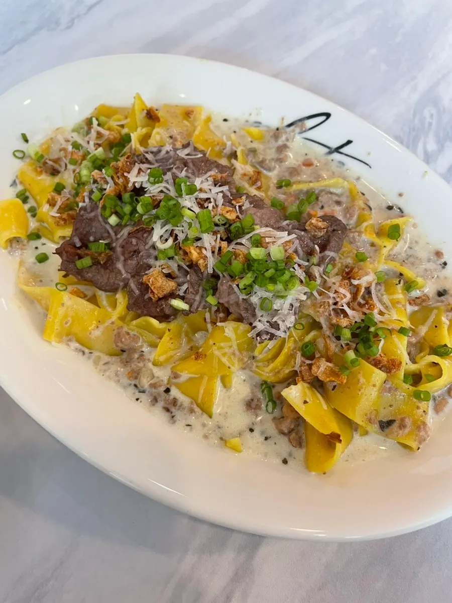 Steak cream ragù pasta với miếng steak bên trên
