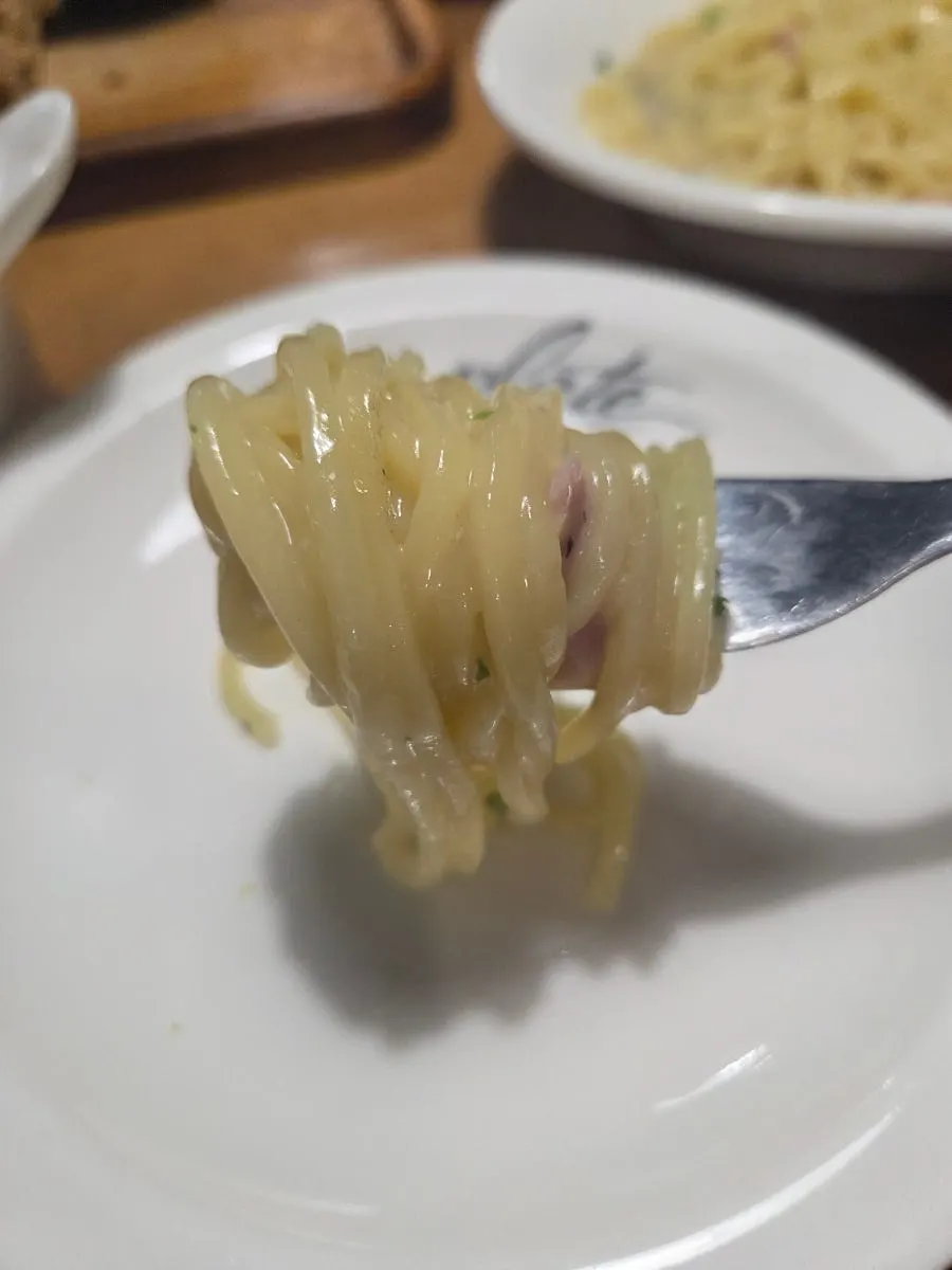 Cream sauce clinging to the fresh noodles in the bacon cacio e pepe