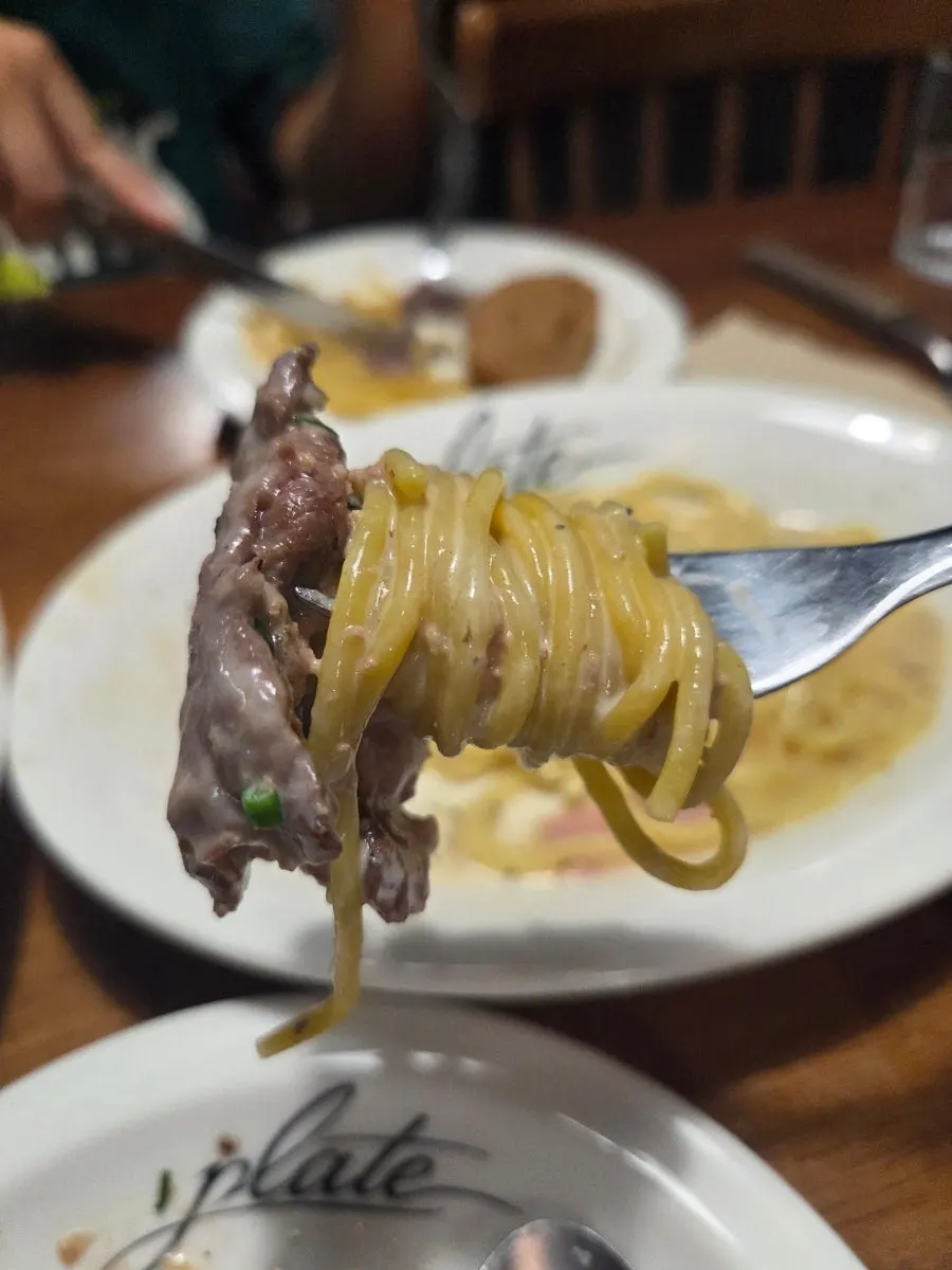 Fresh cacio e pepe noodles lifted with a fork