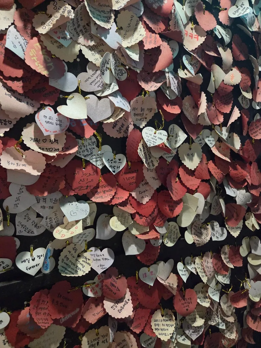 Wall of heart-shaped notes with messages from customers