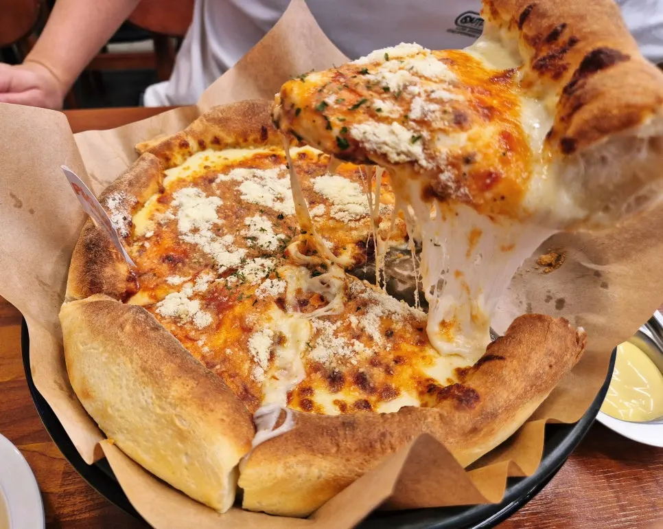 A slice of P&Chick's Chicago pizza with stretchy cheese