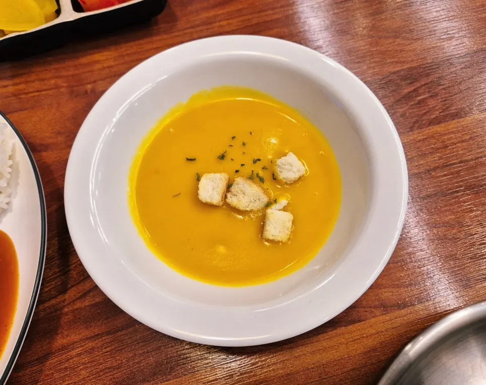 Pumpkin porridge soup served as a side with the cutlet