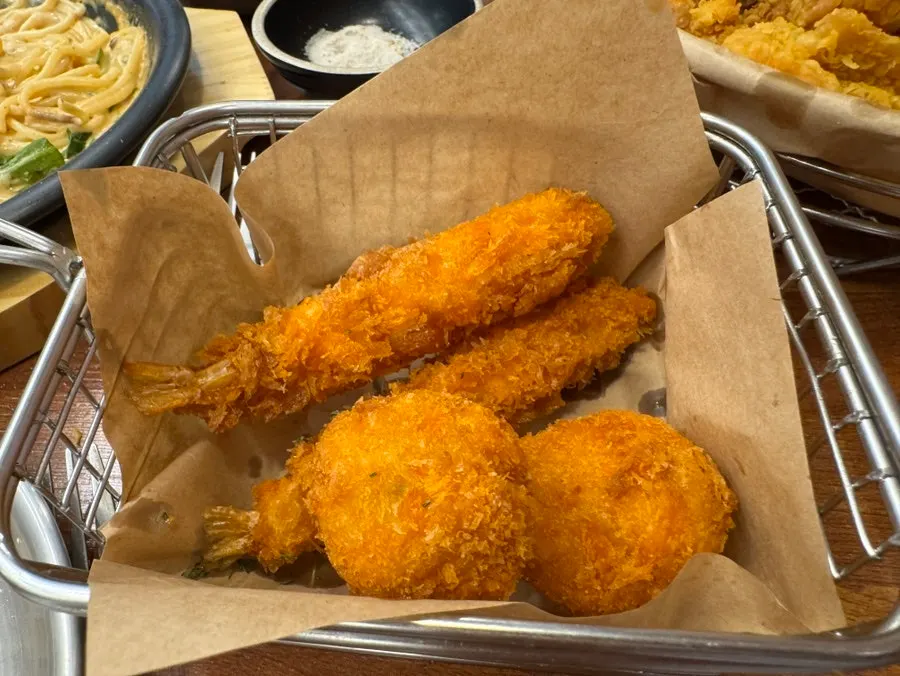 Table with pizza, pasta, and boneless fried chicken together