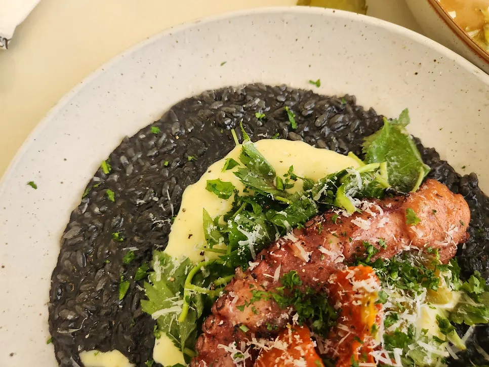 Octopus ink risotto topped with thick octopus legs