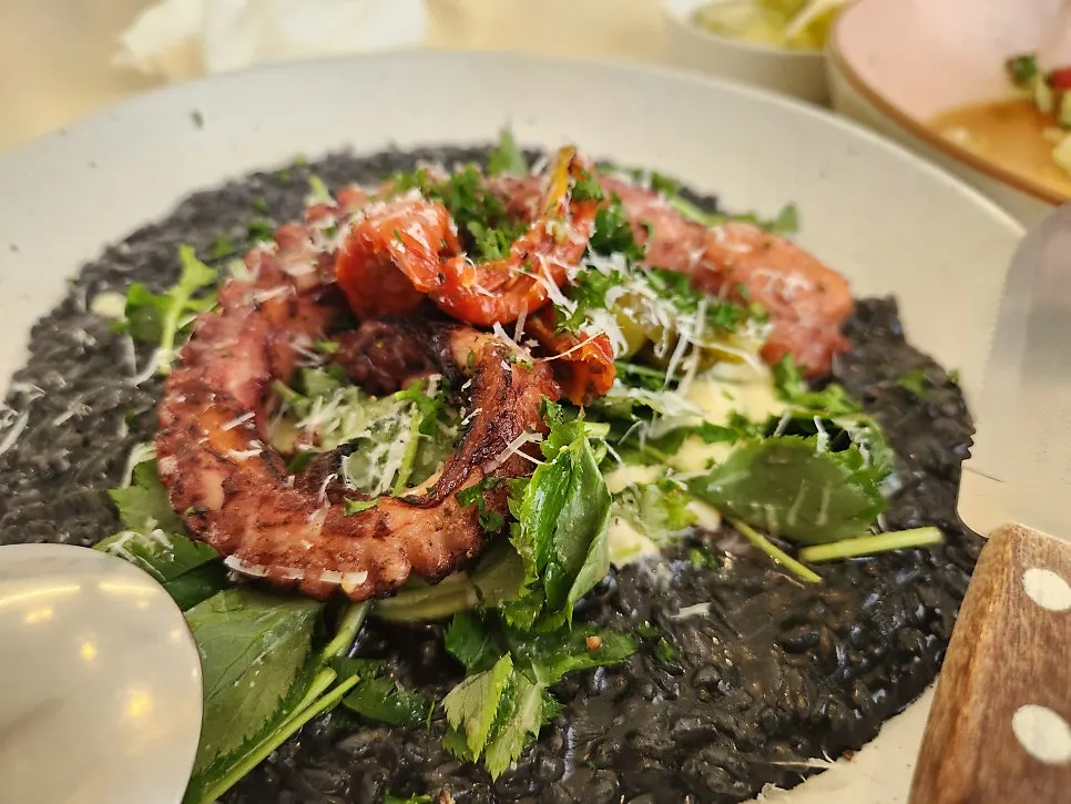 Octopus cut into bite-sized pieces with ink risotto