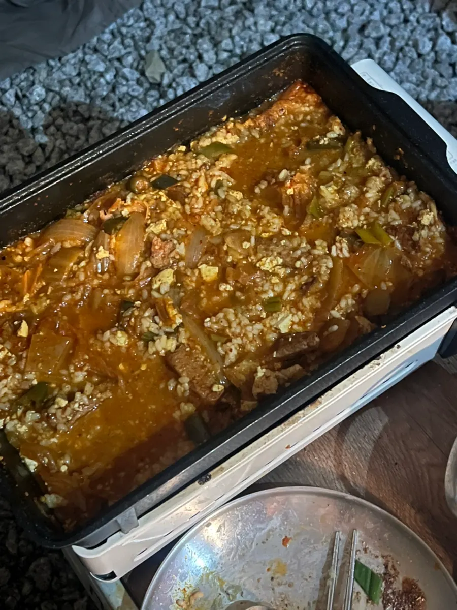 A bubbling pot of kimchi jjigae over the camping stove