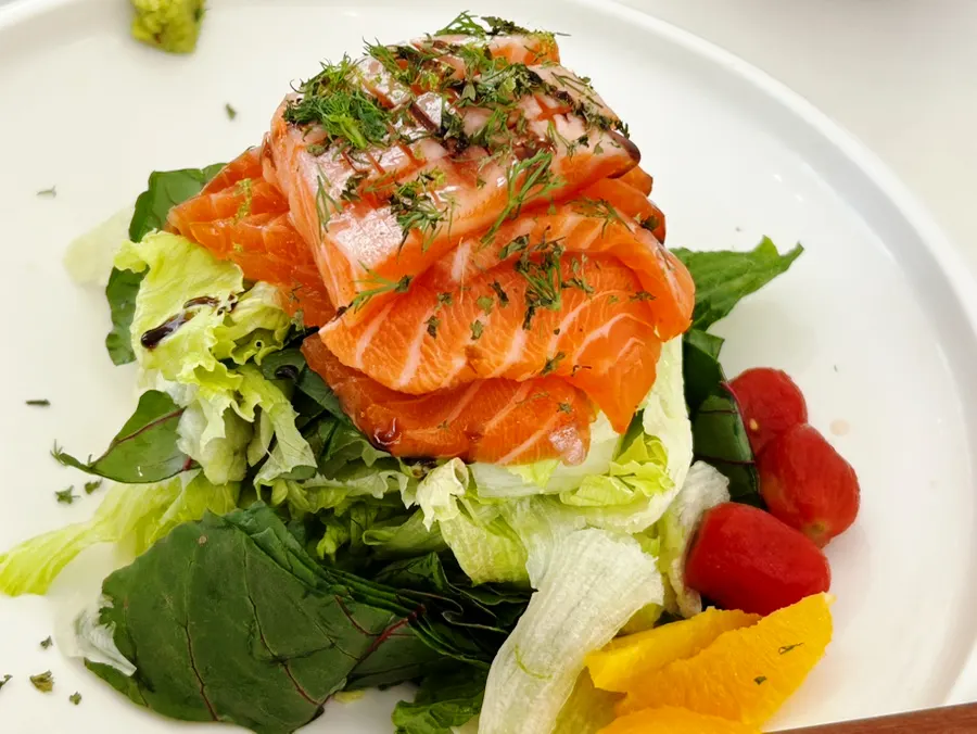 Salad topped with thickly sliced salmon